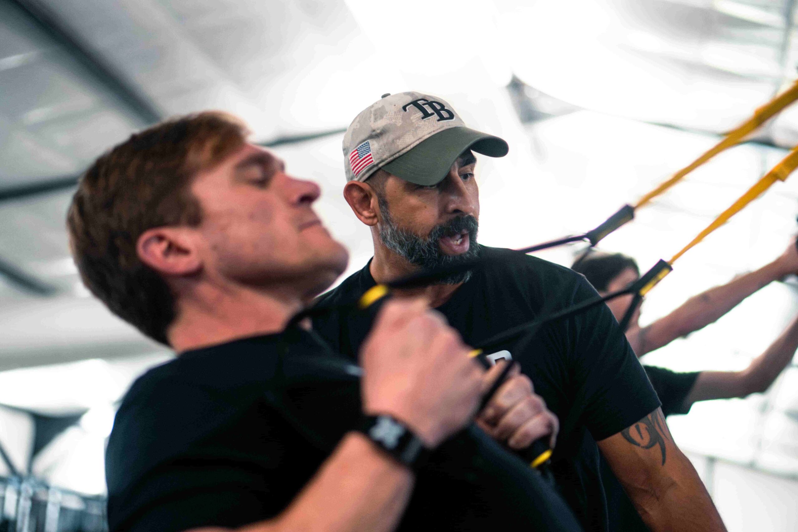 trainer coaching a man on a pull down cable machine moral injury