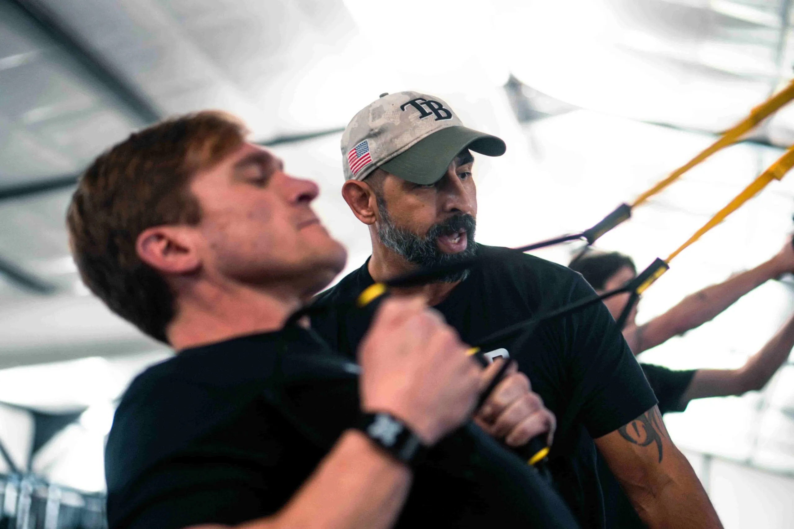 trainer coaching a man on a pull down cable machine moral injury